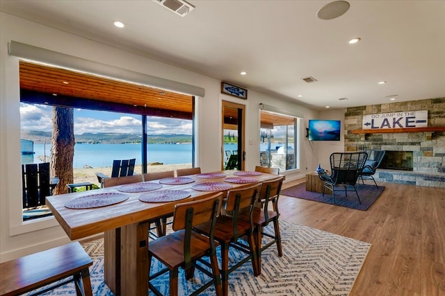 dining room with recessed lighting, visible vents, a fireplace, and wood finished floors