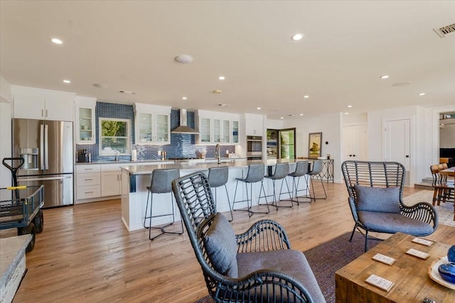 living area featuring recessed lighting, visible vents, and light wood-style flooring