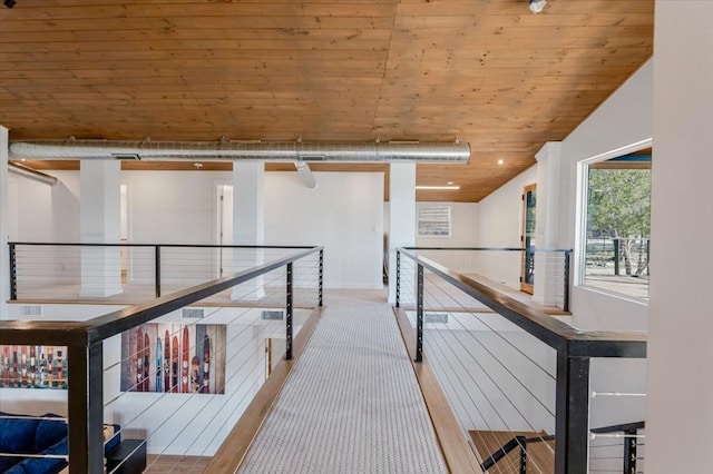 hallway with wood finished floors and an upstairs landing