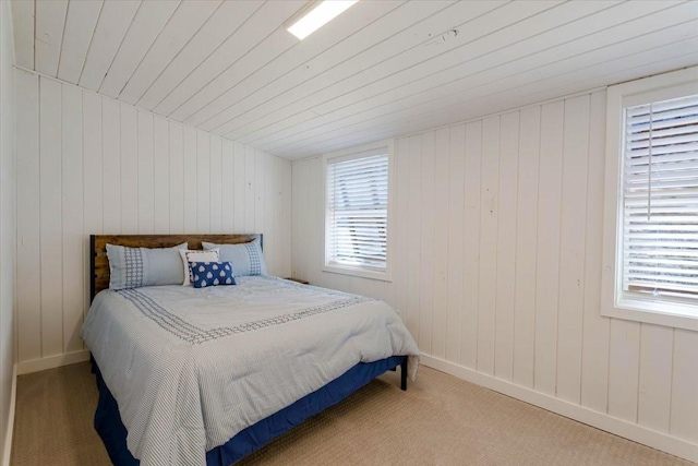 bedroom featuring carpet floors, multiple windows, and wood ceiling