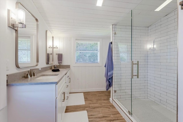 bathroom with plenty of natural light, wood finish floors, a sink, and a shower stall