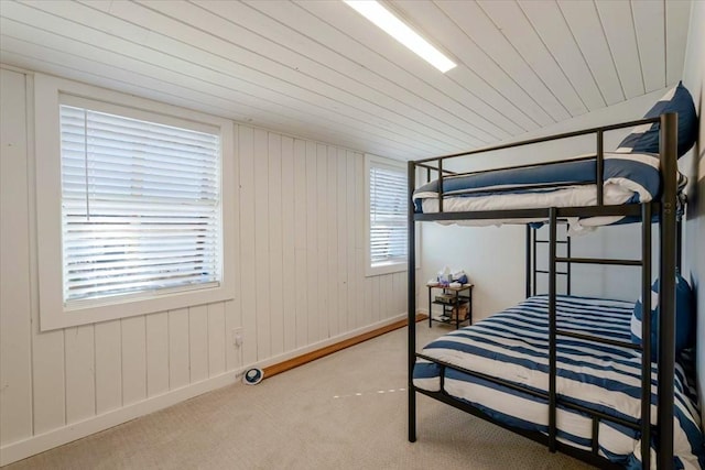 carpeted bedroom with wood ceiling, multiple windows, and baseboards