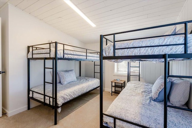 carpeted bedroom with wood ceiling and baseboards