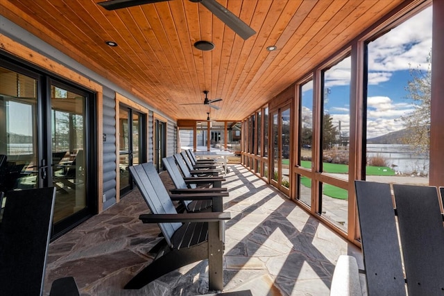 sunroom / solarium featuring a healthy amount of sunlight, wooden ceiling, and ceiling fan