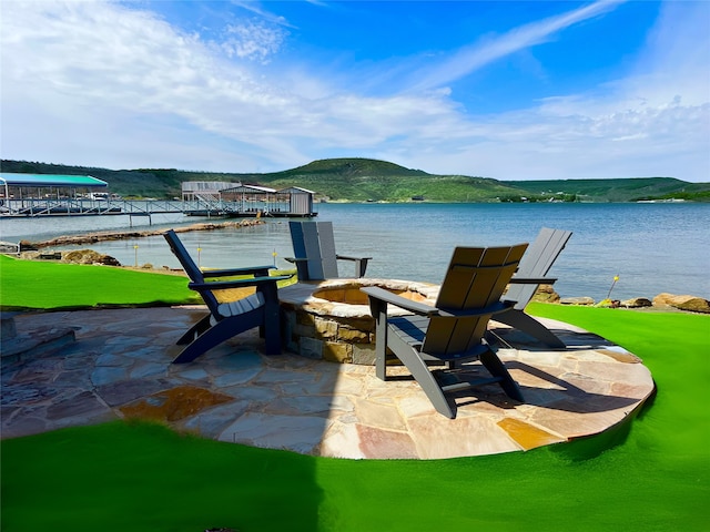 view of patio featuring an outdoor fire pit and a water view