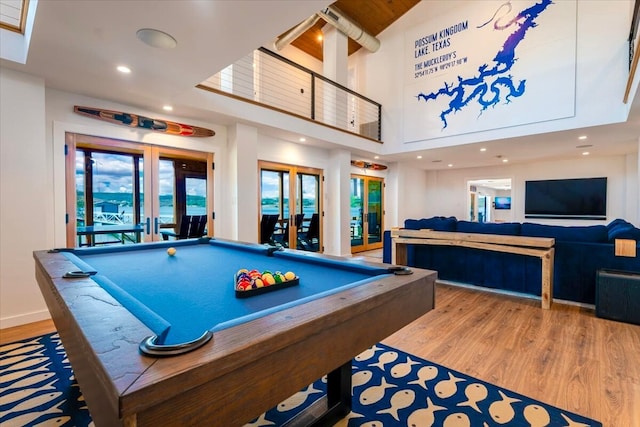 game room featuring recessed lighting, a high ceiling, wood finished floors, and french doors