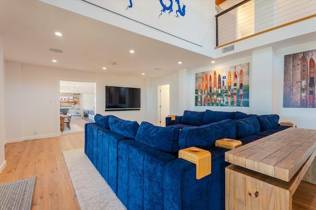 living room featuring recessed lighting, visible vents, a fireplace, and light wood-style flooring