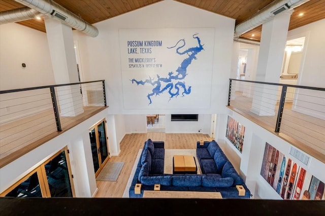 living area featuring vaulted ceiling, wooden ceiling, wood finished floors, and visible vents