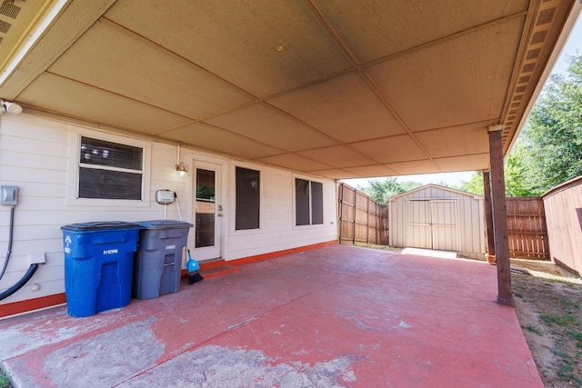 view of patio with a storage shed, an outbuilding, and a fenced backyard