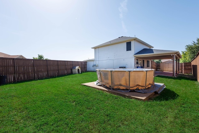 back of house with a fenced in pool, a fenced backyard, and a yard