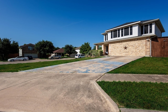 view of front facade with a front yard, concrete driveway, and brick siding