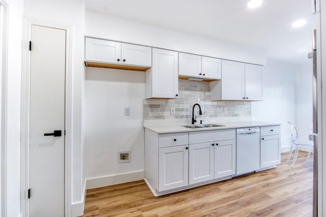 kitchen featuring light wood-type flooring, white cabinetry, white dishwasher, and a sink