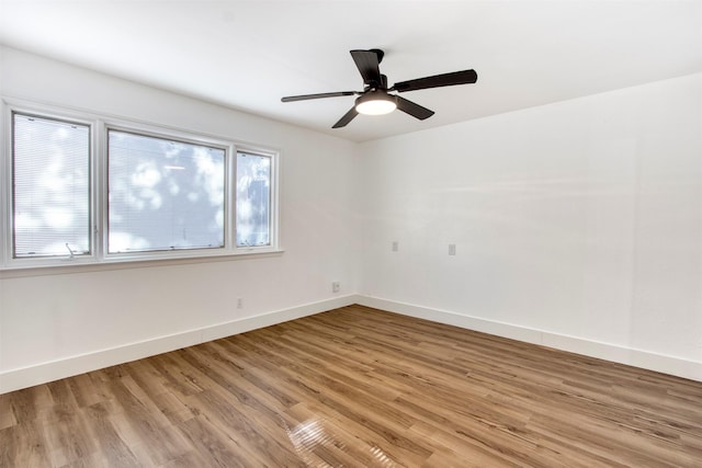 unfurnished room featuring a ceiling fan, baseboards, and light wood finished floors