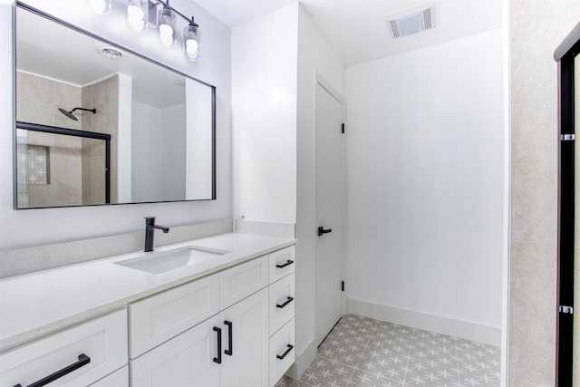 bathroom with vanity, visible vents, baseboards, a shower stall, and tile patterned floors