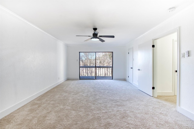 empty room with light carpet, ornamental molding, a ceiling fan, and baseboards