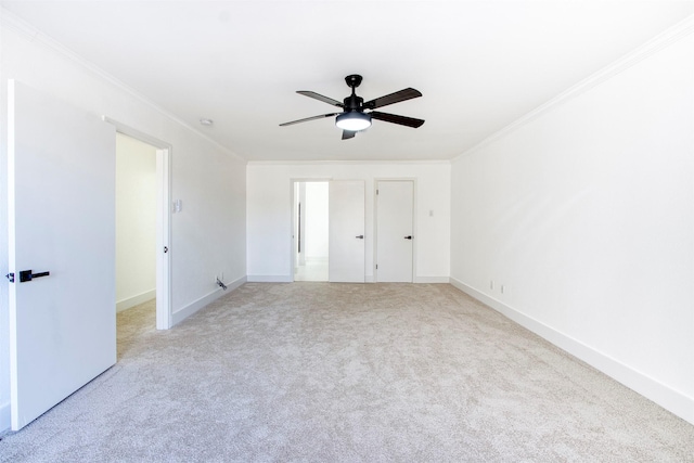 unfurnished bedroom featuring baseboards, carpet flooring, a ceiling fan, and crown molding