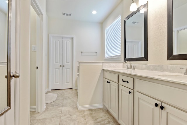 bathroom with visible vents, a sink, and double vanity