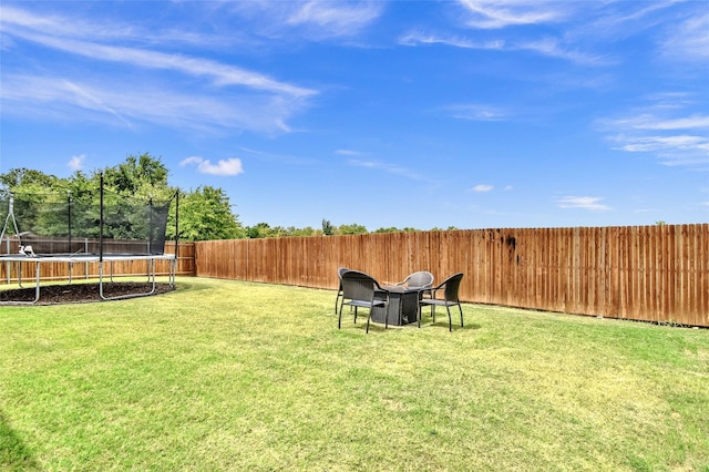 view of yard with a trampoline and a fenced backyard