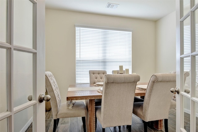 dining area featuring visible vents, wood finished floors, and french doors