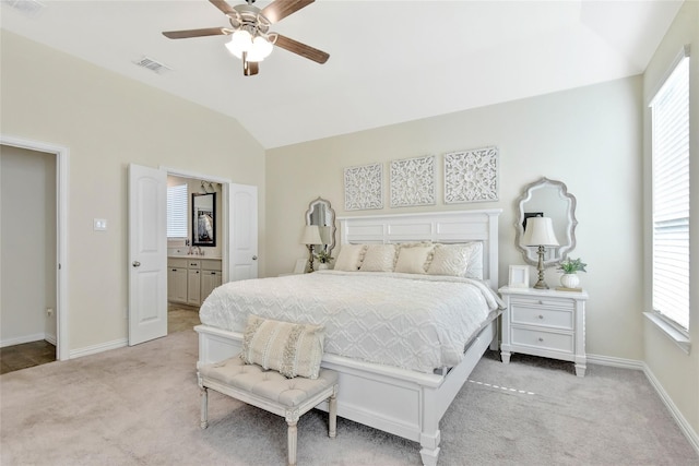 bedroom with light carpet, vaulted ceiling, a sink, and visible vents