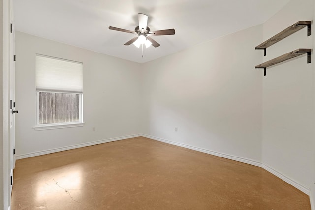 empty room featuring concrete flooring, ceiling fan, and baseboards