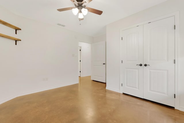 unfurnished bedroom featuring finished concrete flooring, baseboards, visible vents, ceiling fan, and a closet