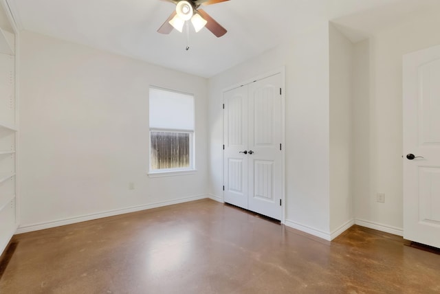 unfurnished bedroom featuring finished concrete floors, a closet, ceiling fan, and baseboards