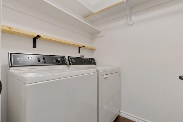 clothes washing area featuring laundry area, baseboards, and washing machine and clothes dryer