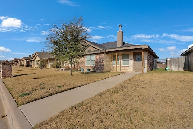 view of front of house with a front yard, fence, and a chimney