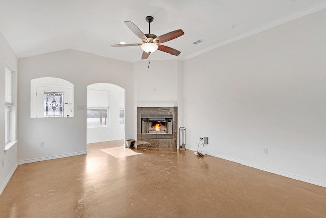 unfurnished living room featuring a tiled fireplace, finished concrete floors, a ceiling fan, vaulted ceiling, and baseboards