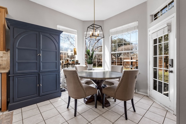 dining space featuring a healthy amount of sunlight, an inviting chandelier, and light tile patterned flooring