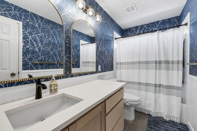 full bath featuring toilet, a wainscoted wall, vanity, visible vents, and wallpapered walls