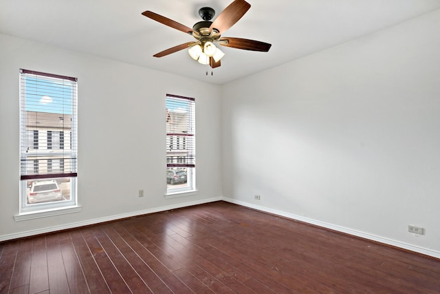 empty room with dark wood-style floors, baseboards, and ceiling fan