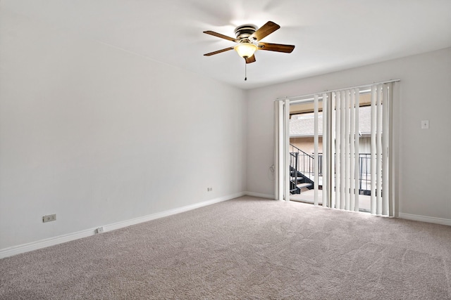 carpeted empty room with a ceiling fan and baseboards