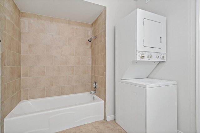 full bath with tile patterned floors, stacked washer and clothes dryer, and shower / bath combination