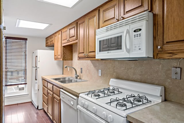 kitchen featuring a sink, white appliances, tasteful backsplash, and light countertops