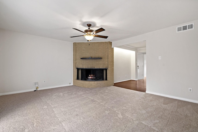 unfurnished living room with visible vents, carpet floors, ceiling fan, and a fireplace