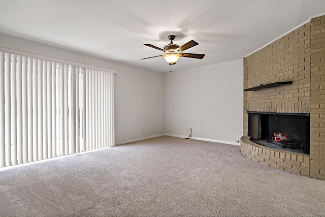 unfurnished living room featuring a brick fireplace, carpet, baseboards, and ceiling fan