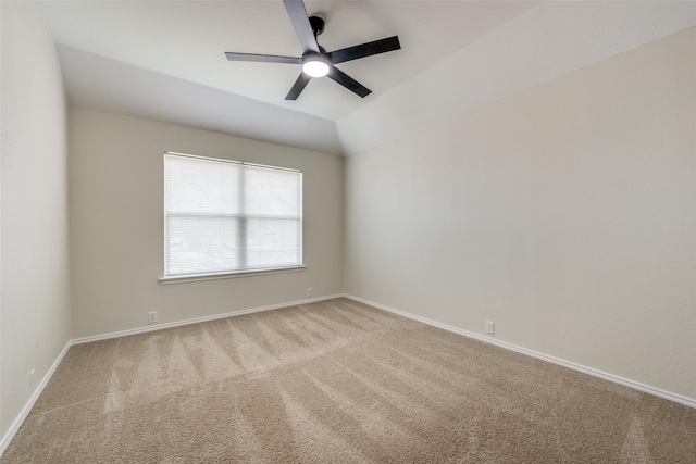 spare room with vaulted ceiling, carpet floors, ceiling fan, and baseboards