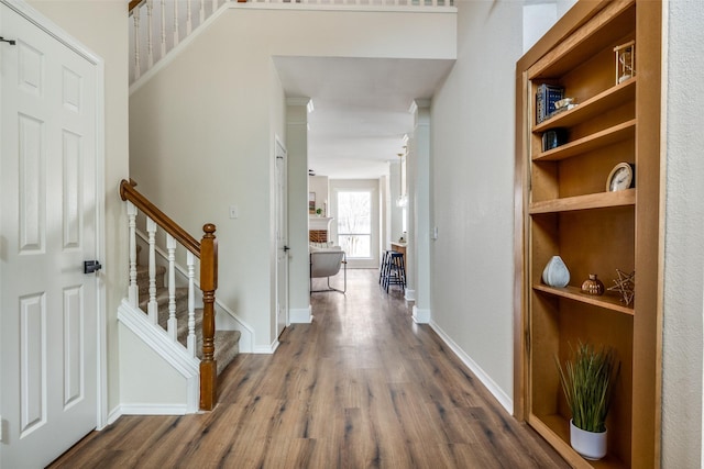 hall with stairs, dark wood-type flooring, and baseboards