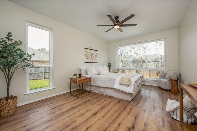 bedroom featuring ceiling fan, baseboards, and wood finished floors