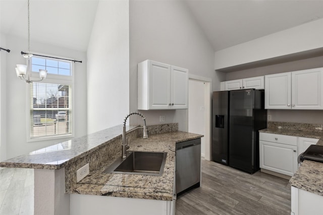 kitchen with a peninsula, a sink, black appliances, light wood-style floors, and white cabinetry