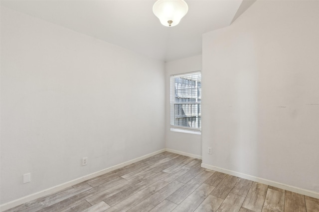 unfurnished room with baseboards and light wood-type flooring