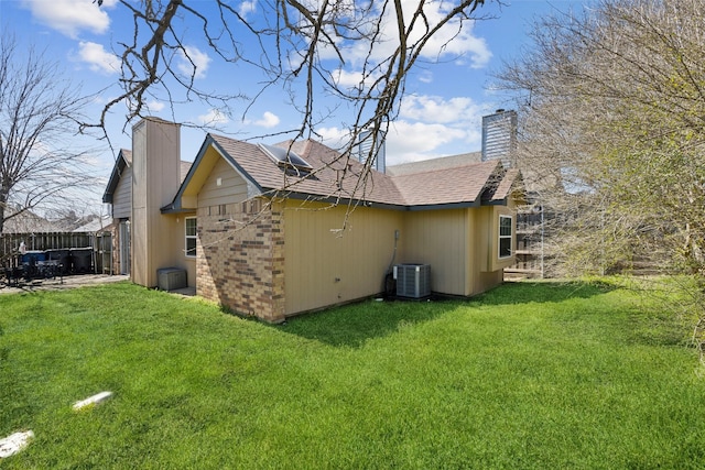 view of property exterior with cooling unit, a lawn, and a chimney