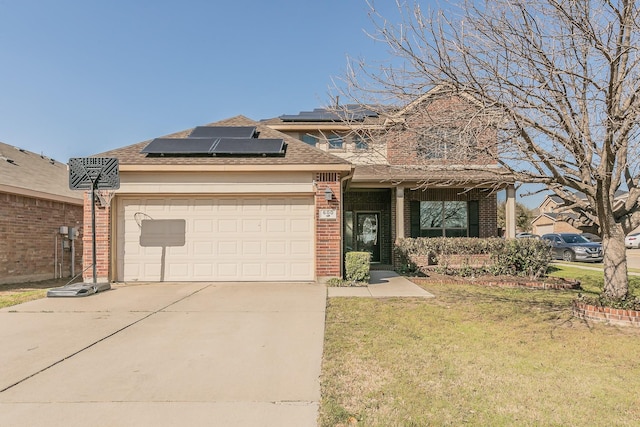 traditional home with brick siding, solar panels, concrete driveway, an attached garage, and a front yard