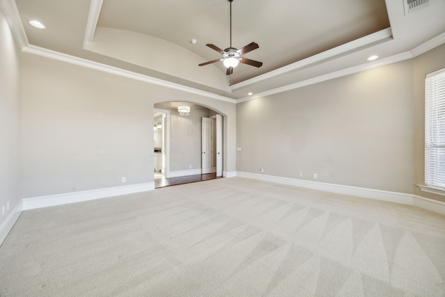 spare room featuring baseboards, recessed lighting, arched walkways, light carpet, and a raised ceiling