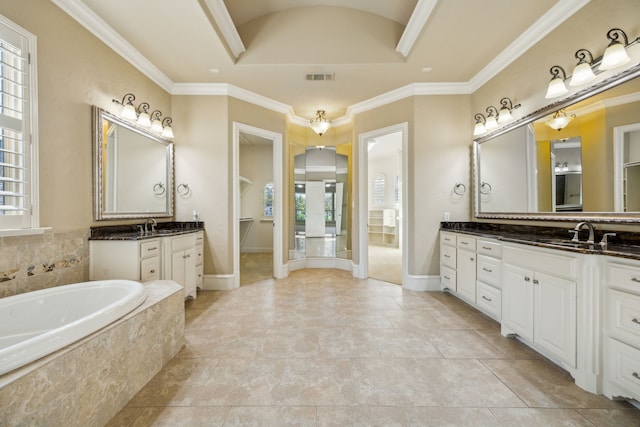 bathroom with a tray ceiling, ornamental molding, two vanities, a bath, and a sink