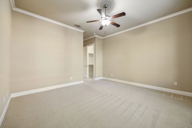 spare room featuring visible vents, light carpet, crown molding, baseboards, and ceiling fan