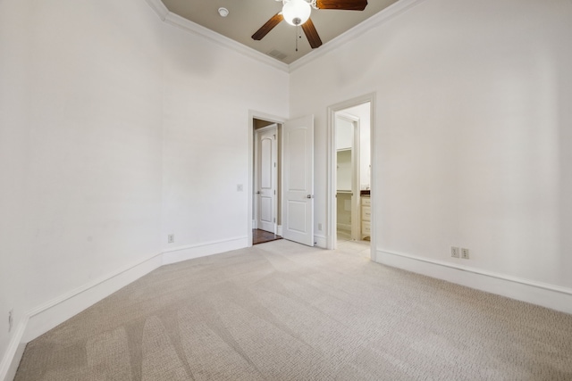 carpeted spare room with visible vents, a ceiling fan, baseboards, and ornamental molding