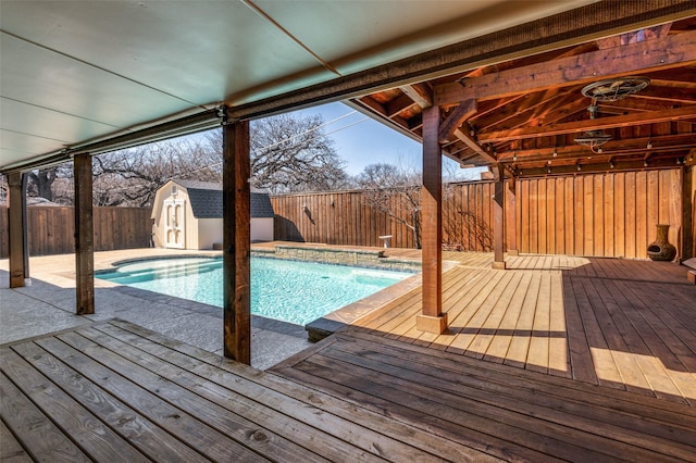 view of pool featuring a fenced backyard, a storage unit, a fenced in pool, and an outdoor structure